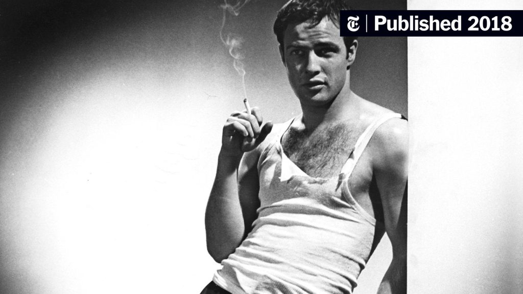 Man wearing white ribbed tank top styled casually with jeans in modern streetwear fashion