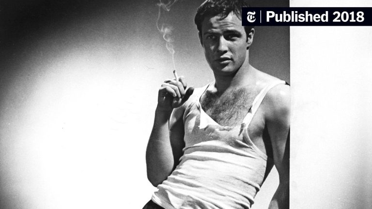 Man wearing white ribbed tank top styled casually with jeans in modern streetwear fashion