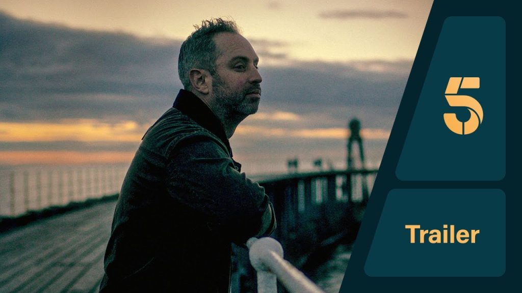 person sitting in distress in a dim room symbolizing hidden abuse and emotional trauma