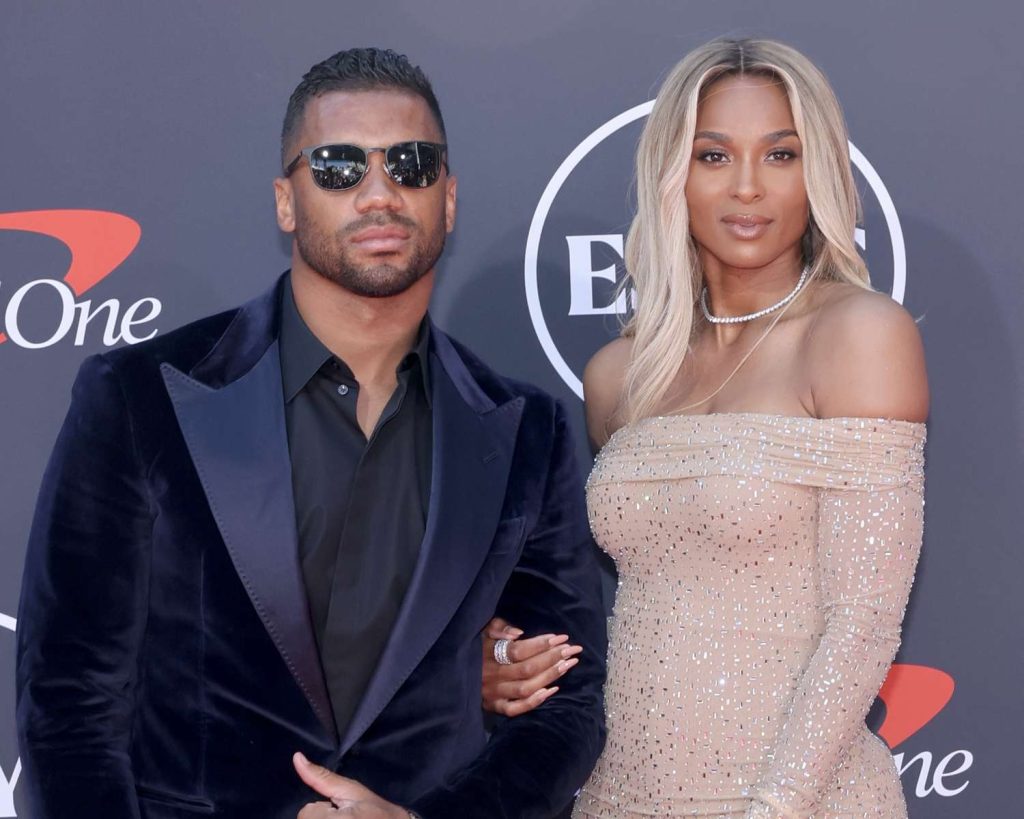 Russell Wilson and Ciara smiling together at a public event showcasing their strong relationship