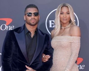 Russell Wilson and Ciara smiling together at a public event showcasing their strong relationship